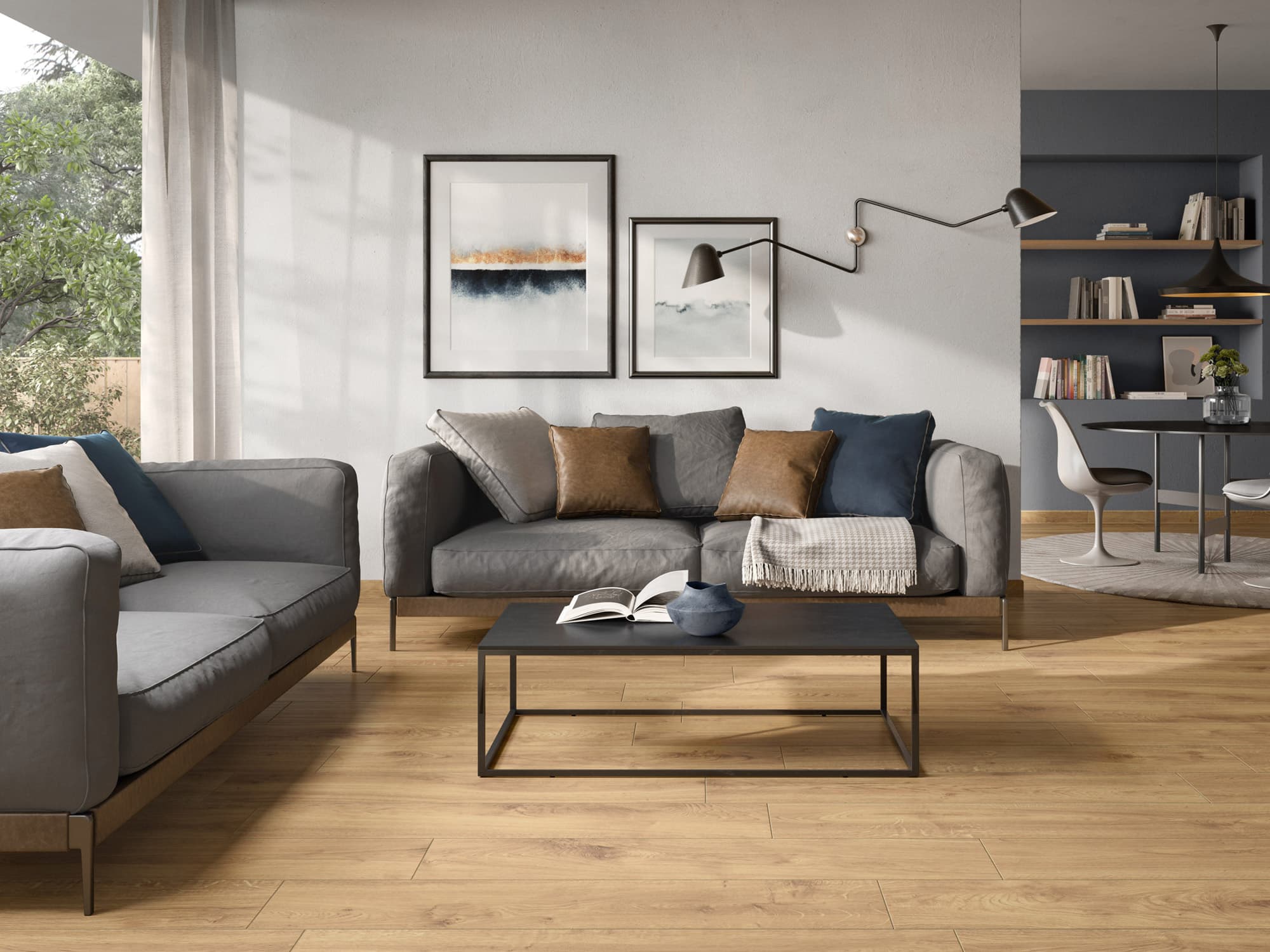Modernes Wohnzimmer mit grauen Sofas, blauen Kissen, Wanddekoration, Fliesenakzenten und Essbereich im Hintergrund